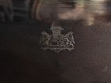 a close up of a silver vase with a coat of arms on it