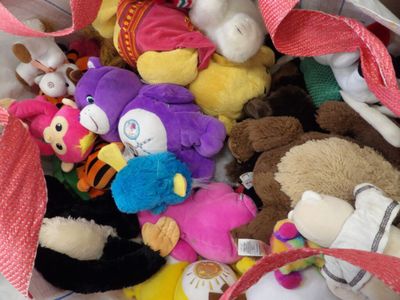 un tas de peluches dans un sac posé par terre