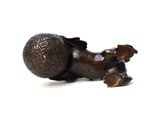 a bronze figurine of a baby laying on its back