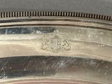 a close up of a silver plate with a bird on it