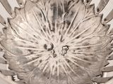 a silver bowl with a flower inside of it