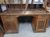 a wooden desk with two chairs on top of it