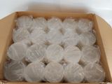 a cardboard box filled with white candles on a table