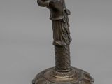 une ancienne statue en bronze représentant une femme tenant un vase