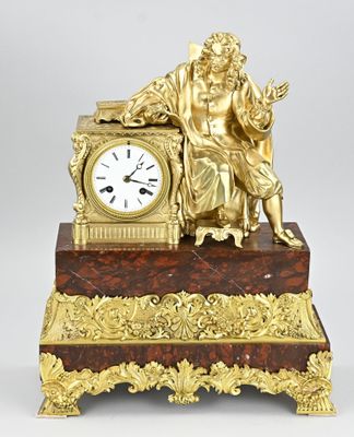 a gold clock sitting on top of a marble table