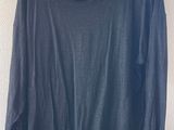 une chemise bleue à manches longues suspendue à un cintre en bois