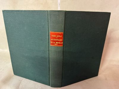 un vieux livre vert avec une étiquette rouge sur la couverture