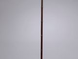 a tall wooden floor lamp with a metal base and a glass shade