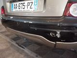 a car that is parked in a garage with a broken bumper