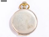 a silver pocket watch on a white surface with a gold ring