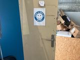 a refrigerator with a sticker on it in the corner of a room