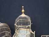 a birdcage with a bird inside of it next to other bird cages