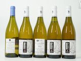 six bouteilles de vin sont alignées sur une table