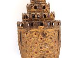 a small gold vase with a castle on it