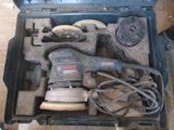 une boîte à outils contenant une ponceuse et d'autres outils