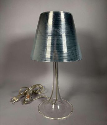 une lampe posée sur une table à côté d'un cordon