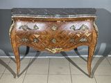 a small chest of drawers with a marble top