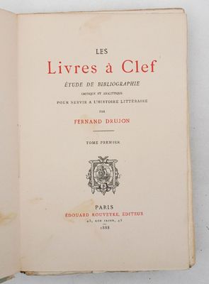 un livre ouvert posé sur une table blanche, avec une couverture rouge