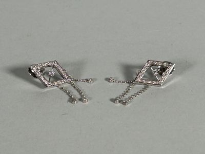pair of white gold and diamond earrings on a white surface