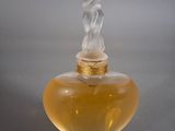 un flacon de parfum en verre avec un bouchon doré et un bouchon blanc