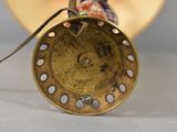 a close up of a gold vase on a table