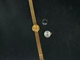 a close up of a watch and a watch on a black surface