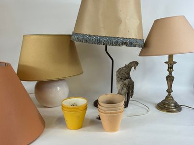 a table with a lamp, vases, and a bird on it