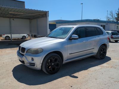 une photo d'un SUV BMW argenté garé sur un parking