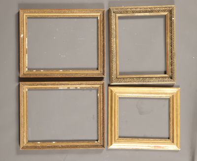 quatre cadres dorés sur un mur gris, avec un miroir