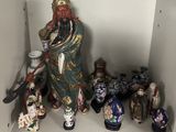 a shelf that has a lot of asian figurines on it