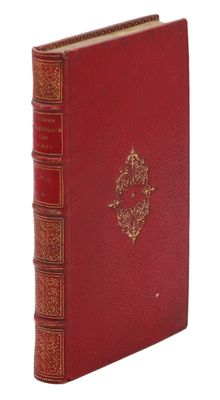 un vieux livre à la couverture rouge et à la bordure dorée