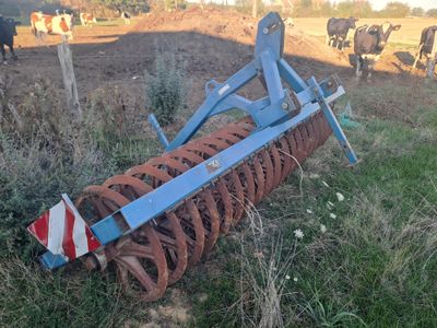 an image of a plow in a field with cows in the background
