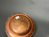 an antique copper plate on a stand on a grey background