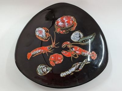 an image of a black plate with lobsters and shells on it