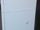 a white refrigerator sitting on top of a cart in a room
