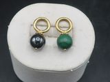 a close up of a pair of earrings sitting on top of a white box