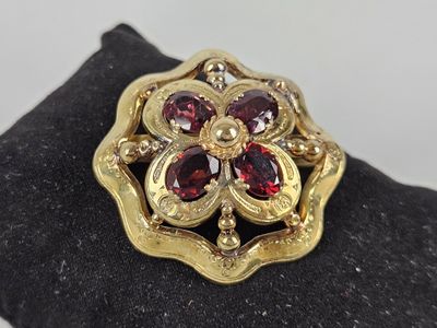 an image of a gold ring with garnets on top of it
