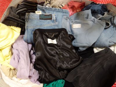 a basket full of clothes that is sitting on the floor