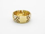 gros plan d'une bague en or sur une surface blanche