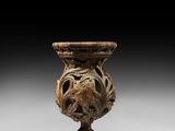 an image of a wooden vase with a face on it
