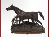 une statue en bronze représentant un cheval et un homme aux commandes d'une charrue
