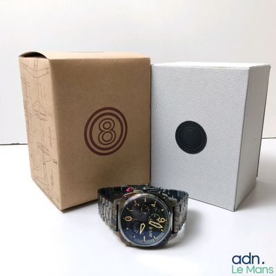 a watch sitting next to a box on a table