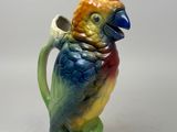 a figurine of a parrot sitting on a tree branch