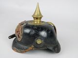 an old black helmet with a gold top on a white background
