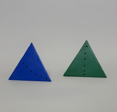 two triangulars with holes in each of them on a white surface