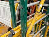yellow and green scaffoldings are stacked on top of each other in a room