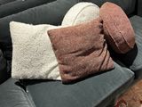 deux oreillers et un coussin posés sur un canapé dans un salon