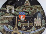 a black plate with a picture of a city on it