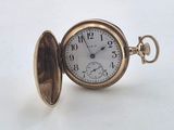 pocket watch on a white surface with a white background