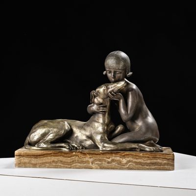 statue en bronze représentant un garçon et un chien, posée sur un socle en marbre